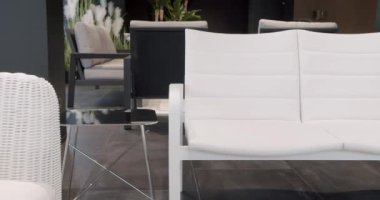 Minimalist sandalyesi ve masası olan beyaz teras mobilyası. Bahçe mobilyaları, Modern Lüks Villa. Minimalist daire. Açık masa ve bahçe parkı için sandalyeler. Lüks villa için modern sandalyeler.