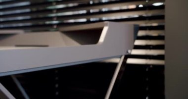 Kapatın ve rahat çalışma odasındaki minimalist deri sandalyeli modern masayı detaylandırın. Oda palmiyesi dekoru. Minimalist siyah panjurlar. Güzellik odasındaki aksesuar. Deri koltuklu ve masalı..