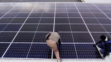 Modern güneş panelleri temiz elektrik üretir. Güneş teknisyenleri evin çatısına güneş panelleri kuruyor. Konsept. Yenilenebilir enerji, teknoloji, elektrik, hizmet, yeşil, gelecek. elektrik santrali. 