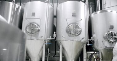 Stainless steel tanks for brewing beer. Huge stainless vats in a brewery. Equipment for beer fermentation. Brewing equipment. Factory, brewery concept. Modern brewery.
