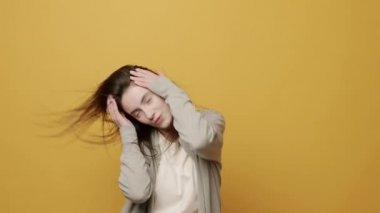 Neşeli Kadın Portresi ellerini oynatmak için ritmik bir şekilde müzik eşliğinde gülümsüyor. Sarı Arkaplanda Zıpla Yavaş Hareket. Dans ediyor, eğleniyor, jestler yapıyor..