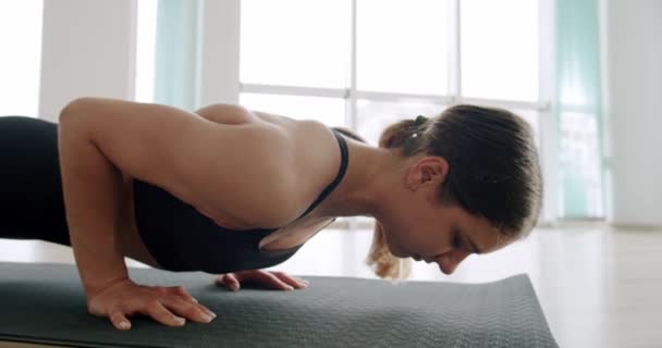 穿着运动服的女运动员正在给腹部抽水 运动美女做俯卧撑作为她的交叉健身 健美体操训练常规的一部分 每日在家练习 — 图库视频影像