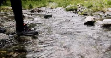 Suya su geçirmez yürüyüş ayakkabıları ve su geçirmez ayakkabıları olan bir adam. Ormanda yürüyen bir adam. Seyahat blogcusu ya da nüfuzlu biri ormanda yürürken ilham verici motivasyon fotoğrafı..