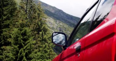 Otomatik seyahat dağda yol dışına. Araba yolculuğu konsepti. Konsept araba seyahati. Dağın arka planında aynası olan, vadi boyunca seyahat eden kırmızı bir dağ arabası görüntüsü..