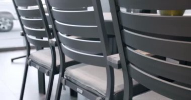 Minimalist sandalyesi ve masası olan siyah teras mobilyaları. Bahçe mobilyaları, Modern Lüks Villa. Minimalist daire. Açık masa ve bahçe parkı için sandalyeler. Lüks villa için modern sandalyeler.