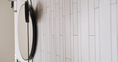 Yuvarlak aynalı modern iç mekan, beyaz renkli minimalist iç mekan banyo aksesuarları, ayna ve lamba modern iç mekan.