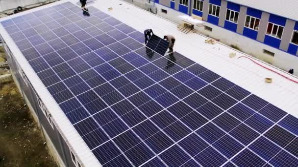 現代の太陽電池パネルはきれいな電気を作り出す 屋根の上にソーラーパネルを設置する太陽技術者 再生可能エネルギー サービス 発電所 — ストック動画