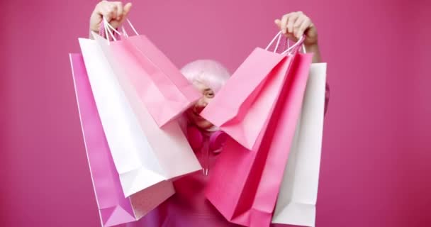 Happy Girl vásárlás után színes táskák rózsaszín színű koncepció. A nő élvezi a kedvezményt és a vásárlásokat. mosolygós sikeres vásárlás után elszigetelt rózsaszín háttér stúdió portré