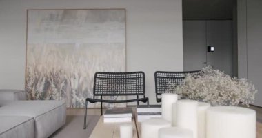Oturma odası minimalist tasarımı, beyaz ve gri tonlu gerçek apartman, şık koltuklar, lüks mobilyalar, projektör, duvardaki televizyon ve beton, minimalist tasarımı olan siyah ses teknikleri.
