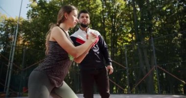 Young girl and man exercising outside. Athletic woman and man doing exercise. Sporty man and woman doing lunges on one leg to strengthen the muscles of the thighs and buttocks.