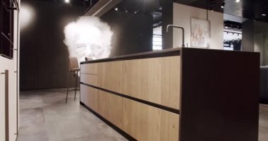 Modern ahşap mutfak mobilyaları. Zarif, rahat ve Minimalist Ev. Modern siyah lavabosu olan yerli mutfak. Minimalist yemek masası olan modern mutfak odası. Modern Minimalist Ev.