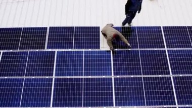 Modern güneş panelleri temiz elektrik üretir. Güneş teknisyenleri evin çatısına güneş panelleri kuruyor. Konsept. Yenilenebilir enerji, teknoloji, elektrik, hizmet, yeşil, gelecek. elektrik santrali. 