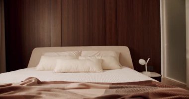 Elegance interior design Minimalist Bedroom Modern Hotel Bedroom Interior and bed with many pillows. Interior with wood on the wall. Real Estate. Interior of modern luxury bedroom with furniture. 