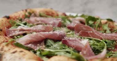 Prosciutto parma jambonlu ve parmesanlı pizza, malzemeli roket roketli roket. İtalyan mutfağı. Strachatella peynirli jambonlu pizza, domates, roka yapraklı..