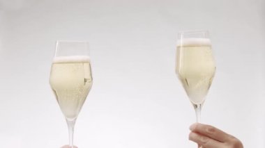 Two glasses of champagne on white isolated background, Cheers. new year celebration. Hands of happy friends cheering celebrating holidays with wine.say a toast, celebrate Christmas party with friends