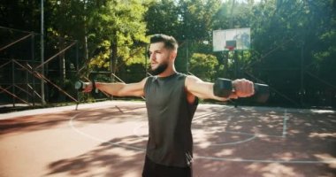Exercises for the hand muscles. Outdoor training on the field of sports exercises. Fit man working out with dumbbells. Gym concept. Healthy lifestyle. dumbbells concentrating working out alone.