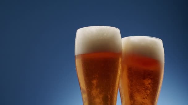 Dois Copos Cheios Cerveja Espumante Colidem Meio Fundo Azul Espuma — Vídeo de Stock