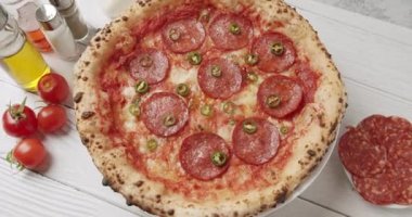  Slow Motion zoom camera on Hot green pepper, pizza ready prepared with pepperoni. Food services. Fresh pepperoni pizza. Delicious Italian pizza Naples. Italy Pizza. Cooking food.