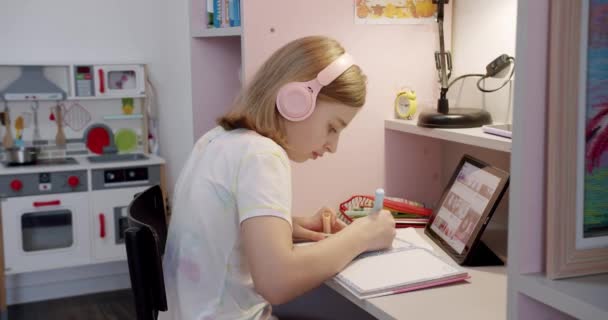 아이들은 식탁에서 그림을 그리고 아이들 분홍색으로 있습니다 숙제를 십시오 헤드폰을 — 비디오