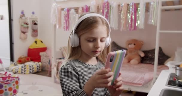 Menina Anos Está Brincando Sala Das Crianças Com Fones Ouvido — Vídeo de Stock