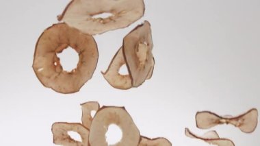 Crispy Apple chips jump and fall on isolated white background. Natural Food. Tasty Food. Slice Apple Chips. Dried fruits apples. Slice Apples. Snack Fast Food. Tasty Apple Chips. 