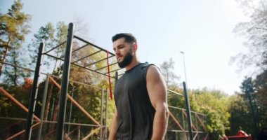 Sporty man looking up before exercising outdoors. Healthy lifestyle and outdoor training. Sports activity with exercises.