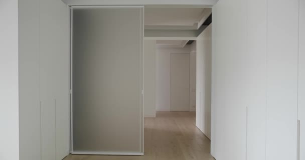 ミニマルなデザインと自動スライドドアと白の色のモダンなインテリア スライドドアを開閉するシステム 現代のスライドドア 居心地の良いアパート 家の中で — ストック動画