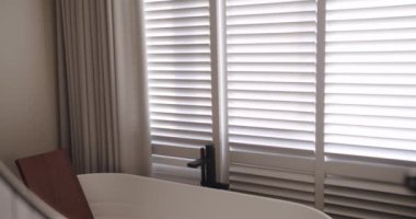 Lüks Banyo İçi, banyo aksesuarları, ayna ve duş başlığı, modern iç mekanda yuvarlak ayna, banyo küveti modern tasarımı olan minimalist iç mimari. Lüks, rahat, beyaz bir daire..
