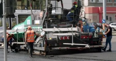 Roadway repair. Heavy machinery. Asphalt Road Construction. Asphalt paver machine on a road construction site. Road Paving on Residential Street. Asphalt laying. 