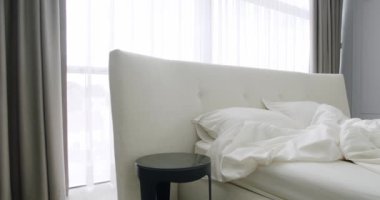 Modern Hotel Bedroom Interior and duble bed with many pillows. Scandinavian style of interior. Elegant and Simple Bedroom With a White King Sized Bed. Elegance interior design. Minimalist Bedroom.