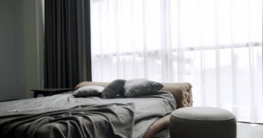 Minimalistic scandinavian style of interior. Elegant and Simple Bedroom With a King Sized Bed. Interior with shelves on white wall. Real Estate. Luxury bedroom with furniture. Brown interior design.
