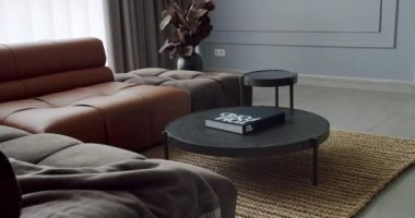 Modern contemporary Minimalist living room with gray and brown furniture. Luxury Modern House Interior With Corner Sofa and round table. Fashionable furniture. Modern Furniture Design. Luxury Room