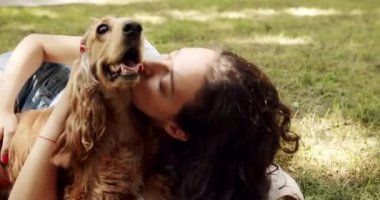 Woman playing with her dog. hugs, kiss and pose nicely. Human animal friendship. English cocker spaniel rests outdoors. young pretty animal. Happy woman hugs and have fun with cocker spaniel dog.