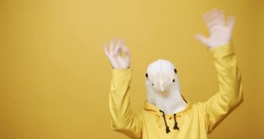 Man with Pigeon Mask. Fun and happiness concept. Funny Guy in Yellow Suits Dance with Pigeon Mask, Man having fun on isolated Yellow Background. Having Fun, Party Halloween. Slow Motion. Fools Day. 