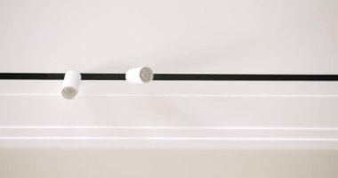 Daireyi veya evi modern beyaz lambalarla dekore ederken minimalist asma tavan ve alçı kaplama yapı. Dolly ile video. Lambalı Modern Tavan. Minimalist İçişleri