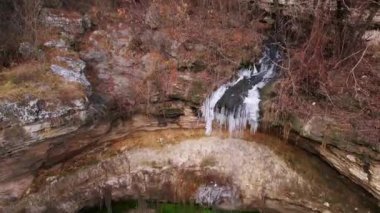 Buzlu küçük şelale, ıslak kayalar ve yeşillikler, Avrupa 'da arkeolojik turizm merkezi