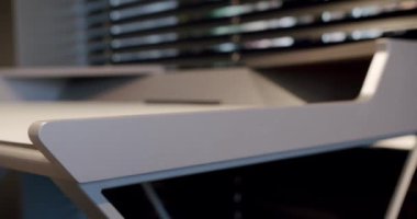 Kapatın ve rahat çalışma odasındaki minimalist deri sandalyeli modern masayı detaylandırın. Oda palmiyesi dekoru. Minimalist siyah panjurlar. Güzellik odasındaki aksesuar. Deri koltuklu ve masalı..