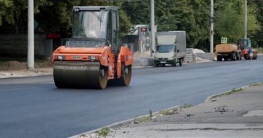 Asphalt laying. Road building asphalt paver is laying a new layer of asphalt, Road rollers drive on a new road. Asphalt paver machine on a road construction site. Roadway repair. Heavy machinery.