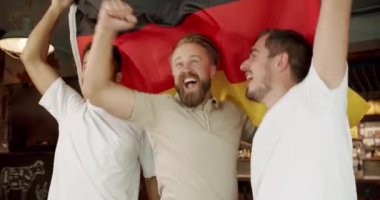 Soccer fans celebrating victory of team in sports bar. Happy mixed race supporters cheering and exulting after winning. Happy Men with the flag of the national country of Germany