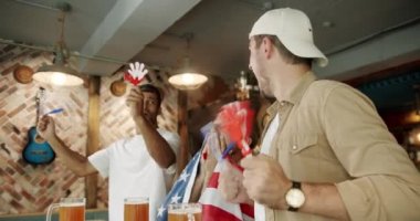 Men with the flag of the national country of USA drinking beer and watching sport game. World Cup, football, hockey, basketball, sports games. Soccer fans celebrating victory of team in sports bar.