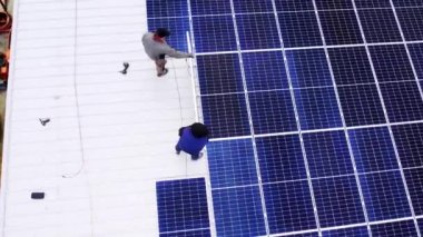 Modern güneş panelleri temiz elektrik üretir. Güneş teknisyenleri evin çatısına güneş panelleri kuruyor. Konsept. Yenilenebilir enerji, teknoloji, elektrik, hizmet, yeşil, gelecek. elektrik santrali. 