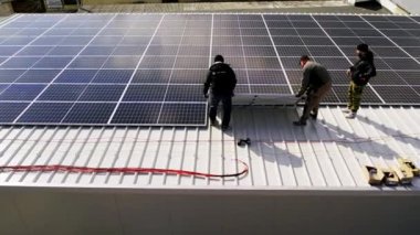 Modern güneş panelleri temiz elektrik üretir. Güneş teknisyenleri evin çatısına güneş panelleri kuruyor. Konsept. Yenilenebilir enerji, teknoloji, elektrik, hizmet, yeşil, gelecek. elektrik santrali. 