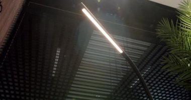 Siyah minimalist ve modern doğrusal zemin lambası. İçi siyah ve ahşap çizgili. Işıklandırma ekipmanlarıyla minimal iç mekan. Modern lamba. Şatafatlı Avize.