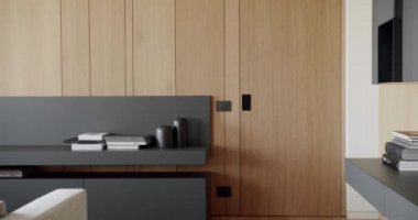 Ahşap duvarlı ve gri mobilyalı modern çağdaş. Gri kitaplıklı lüks Modern Ev İçi. Modern rafları ve kitabı olan minimalist bir iç mekan. Ahşap modern kapısı olan lüks şık bir oda.