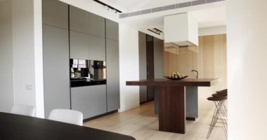 Modern mutfak ve bar kahverengi sandalyeler minimalist dairede mutfak odasında. Modern Açık Konsept Ev İçi. Minimalist mutfak odası beyaz renklerde ve yemek alanı da doğal ahşap.
