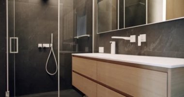 Ayna ve duş başlığı, küvet modern tasarım. Sıcak, beyaz bir daire. Basitlik tasarımı olan modern banyo. Lüks banyo iç mimarisi, minimalist iç dekorasyon kahverengi renkli banyo aksesuarları.