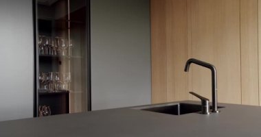 Yeni moda mobilyalarla dolu güzel bir mutfak. Minimalist bir mutfağın içinde. Açık Ahşap Duvar ve Zemin. Minimalist yemek masası olan modern mutfak odası. Modern lavabolu Ev Mutfağı