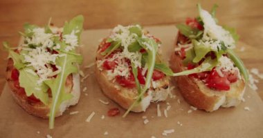 Çeri domatesli, peynirli ve roka aromalı lezzetli bruschetta hamur tostu. Restoranda geleneksel İtalyan kahvaltı yemeği, 4K shot. Sağlıklı yemek ve diyet kavramı. Sağlıklı, vejetaryen yiyecekler.