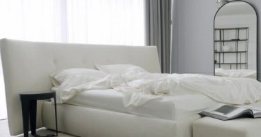 Zarif iç tasarım. Minimalist yatak odası. Modern Hotel Yatak Odası İçi ve Çift kişilik yatak. Minimalist İskandinav tarzı iç mekan. Beyaz Kral yatağı olan basit bir yatak odası. Gayrimenkul.