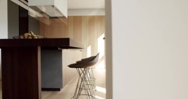 Yeni moda mobilyalarla dolu güzel bir mutfak. Minimalist yemek masası olan modern mutfak odası. Modern lavabosu olan yerli mutfak. Mutfak odası beyaz renklerde ve yemek alanı da doğal ahşap.